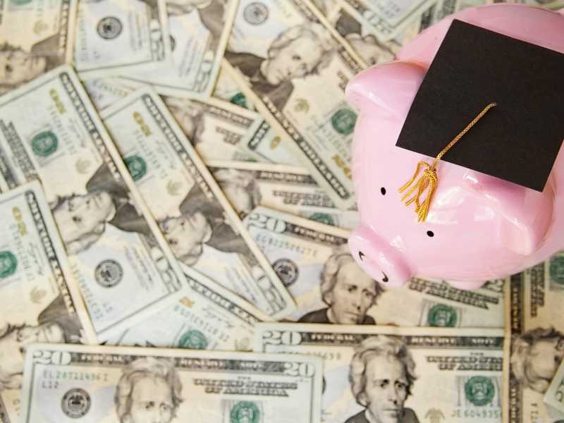 piggy with graduation cap on money